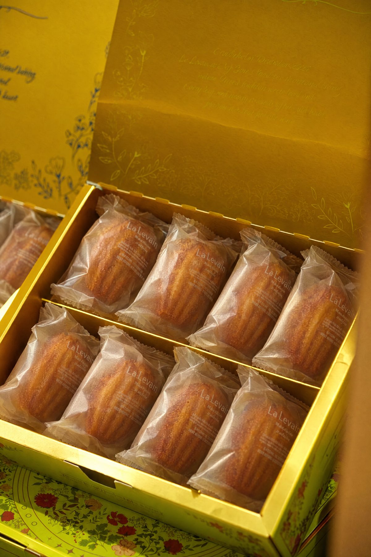 A gold La Levain gift box holding individually wrapped madeleines